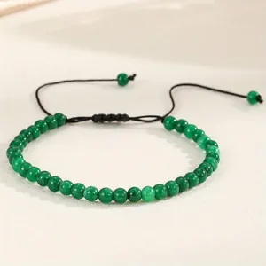 Close-up of 4mm green natural agate beads on a braided adjustable yoga bracelet