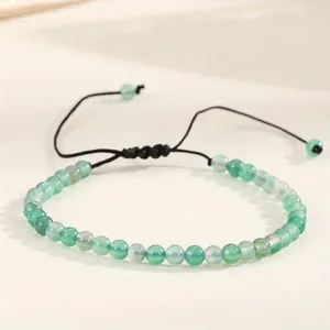 Close-up of 4mm green natural agate beaded bracelet with an adjustable black cord.