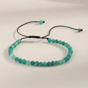 Detailed view of 4mm green natural agate beads on an adjustable braided bracelet.