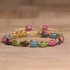 Close-up of 4mm natural tourmaline stones on a colorful woven adjustable bracelet