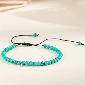 Macro detail of a 4mm turquoise-colored stone bead yoga bracelet with adjustable cord