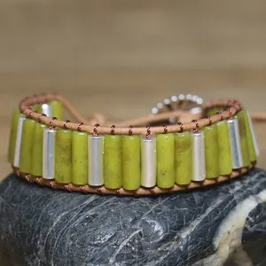 Detailed view of handmade olive green stone and silver tube woven wrap bracelet