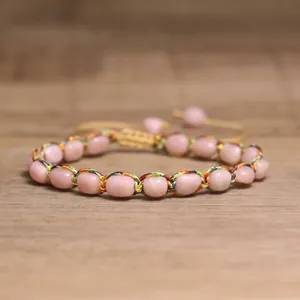 Macro detail of 4mm pink tourmaline beads woven into a colorful adjustable braided bracelet