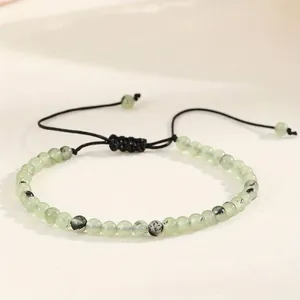 Macro detail of 4mm green natural agate beads on a black adjustable woven cord