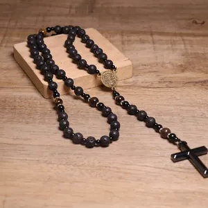 Detalle de collar de rosario religioso para hombre con cuentas de lava y cruz de hematita