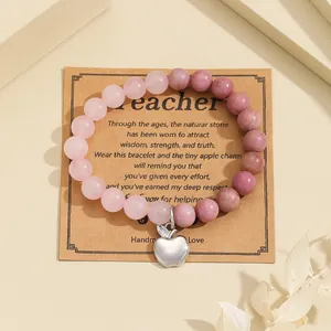 Detailed shot of natural pink stone bracelet with apple charm on teacher gift card
