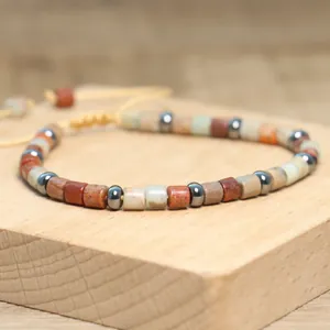 Detailansicht eines böhmischen Natursteinarmbands mit einer verstellbaren, gelben Kordel.