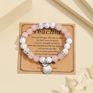 Detail of handmade teacher gift bracelet featuring pink natural stones and apple heart charm