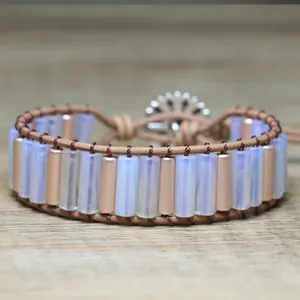 Detailed view of handmade woven bracelet with opal-like beads and flower button clasp