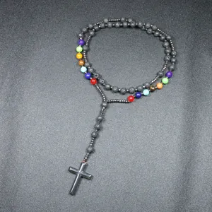 Detailopname van 8mm lavastenen kralen en hematiet kruis aan een chakra ketting