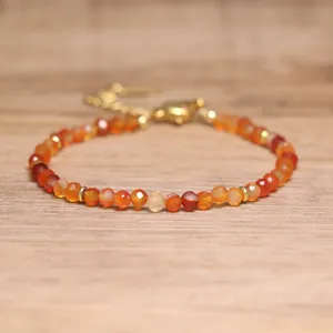 Close-up of faceted natural carnelian beaded bracelet with adjustable gold chain