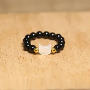 Close-up of cute cat-shaped bead ring with black and gold stones on elastic rope