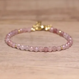 Close-up of natural pink stone faceted beads on a handmade adjustable bohemian bracelet.