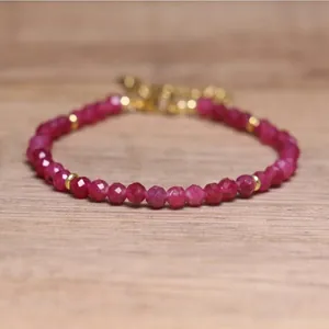 Detailed view of faceted red natural stone beads on a handmade adjustable bracelet.
