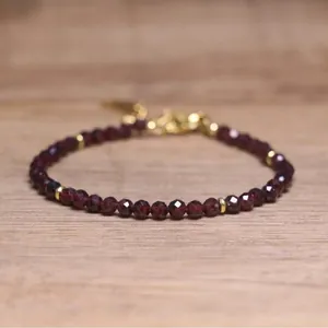 Detailed macro view of faceted burgundy stone beads with elegant gold spacer beads