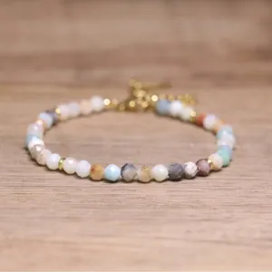 Detailed view of handmade faceted natural stone beaded bracelet with bohemian style charm
