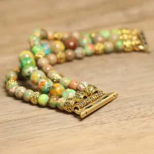 Macro-opname van de drielaagse kralenarmband van natuursteen met gouden connectoren