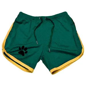 Detail von grünen Mesh-Sportshorts mit gelber Borte und Pfotenabdruck-Logo