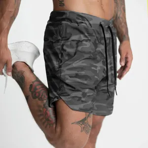 Dettaglio pantaloncini da corsa 2-in-1 uomo mimetici scuri con spacco laterale sportivo.