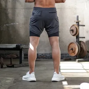 Vista posteriore di pantaloncini sportivi 2-in-1 grigi professionali da uomo in palestra