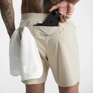 Dettaglio dei pantaloncini sportivi beige 2 in 1 con passante per asciugamano e tasca