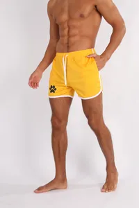 Detailansicht der gelben Mesh-Schnelltrocken-Laufshorts mit einem Pfotenabdruck-Logo