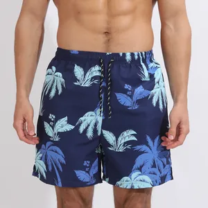 Détail de l'imprimé palmier sur le short de bain bleu marine avec cordon de serrage.