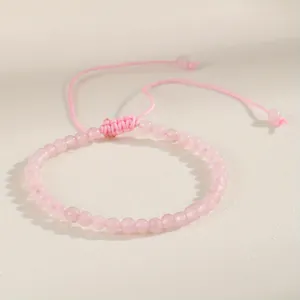 Macro view of a 4mm pink natural stone bead bracelet with adjustable woven cord