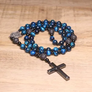 Detailed macro view of blue tiger eye rosary beads featuring a sleek hematite cross pendant