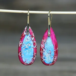 Detailopname van druppeloorbellen met roze en blauwe natuurlijke steentextuur