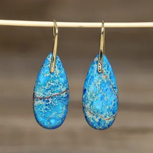 Detailopname van prachtige druppelvormige oorbellen van natuurlijk blauwe jaspis