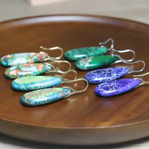 Gedetailleerde close-up van keizerlijke jaspis druppeloorbellen op houten dienblad
