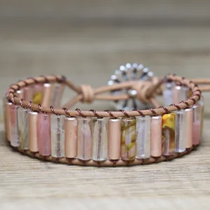 Close-up of handmade woven bracelet with pink stone beads and floral button clasp