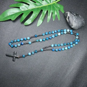 Detailed view of handmade necklace with blue striped agate beads and hematite cross pendant