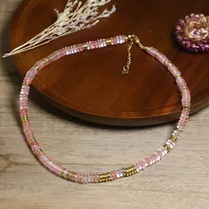 Dettaglio di una collana bohémien fatta a mano con perle in pietra naturale rosa e oro