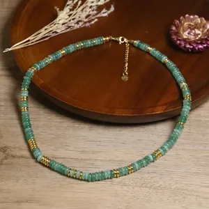 Dettaglio di collana boho fatta a mano con pietre naturali verdi e distanziatori oro.