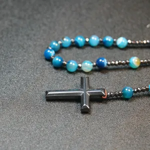 Detail view of blue striped agate beads and black hematite cross rosary necklace.