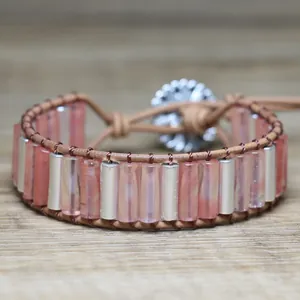 Detailed macro view of a handmade woven leather bracelet with pink beads and flower clasp