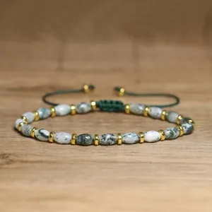 Detailed view of handmade moss agate beaded bracelet with green woven adjustable cord