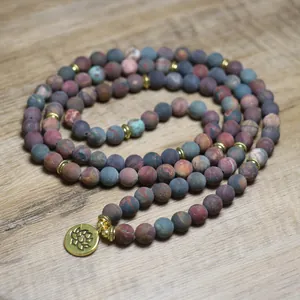 Detailed view of 108 Picasso stone mala beads with gold lotus charm and natural texture