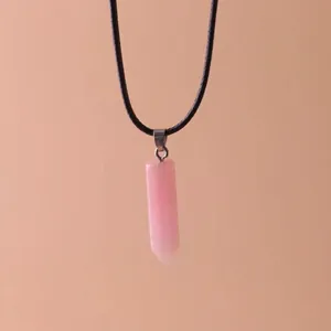 Close-up of a pink hexagonal crystal quartz column pendant necklace on a black cord
