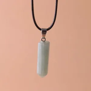 Macro view of a hexagonal light green quartz crystal pendant on a black cord necklace