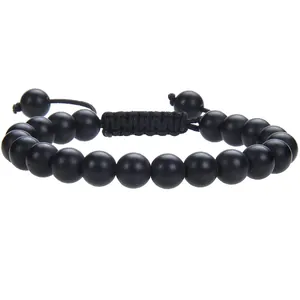 Gedetailleerde close-up van 8mm matzwarte stenen kralen op een handgeweven macramé armband