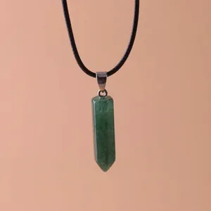 Macro view of a hexagonal green quartz crystal pendant on a black cord necklace