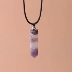 Close-up of a hexagonal purple crystal pillar pendant hanging on a simple black cord