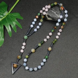 Detailopname van een kralenketting van natuursteen met een strakke driehoekige hanger.
