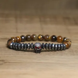 Detailed view of gothic skull charm bracelet with faceted hematite and tiger eye stone beads