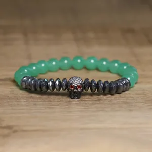 Detailed view of a gothic skull charm bracelet featuring green stone beads and hematite.