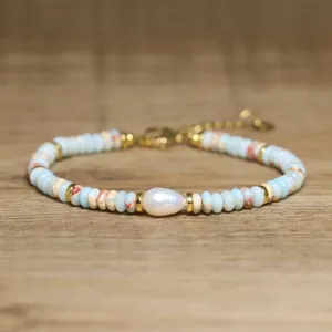 Detailed view of a handmade bracelet featuring a baroque pearl and blue natural stone beads