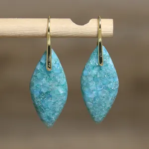Detailaufnahme von markisenförmigen Ohrringen aus blauem Kaiserstein mit Goldhaken.
